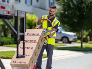 Vantive worker in yellow safety vest wheeling Vantive boxes into truck
